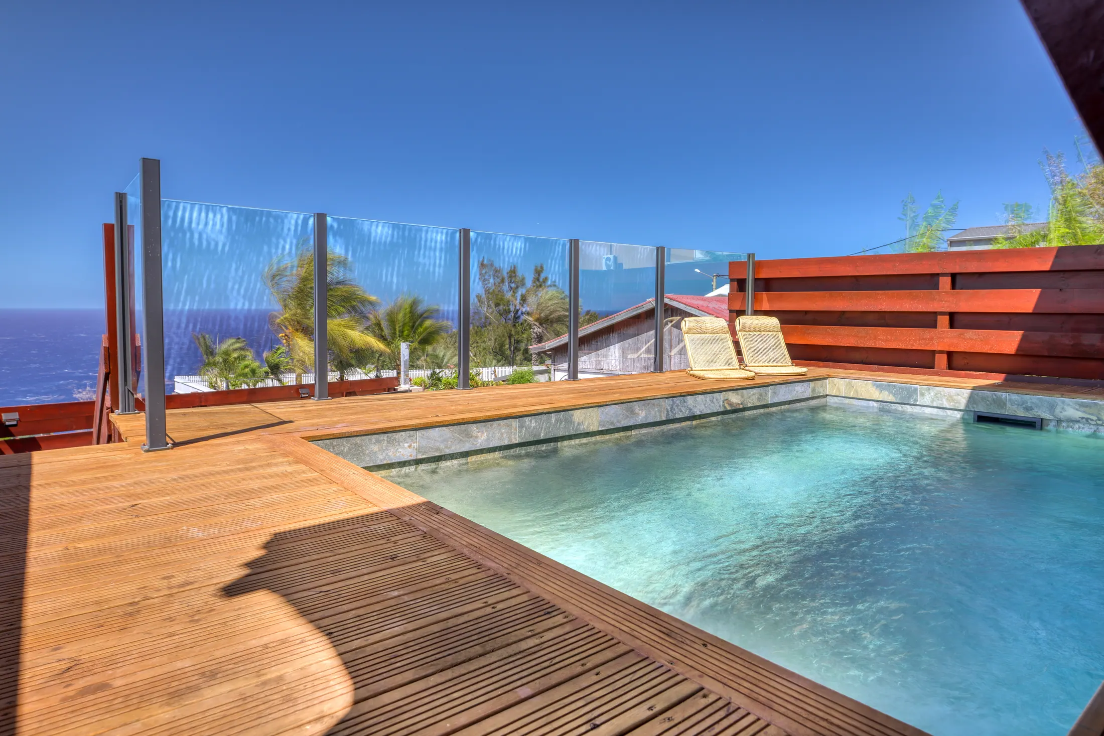 Piscine et terrasse bois de la Villa Petite Anse avec vue mer